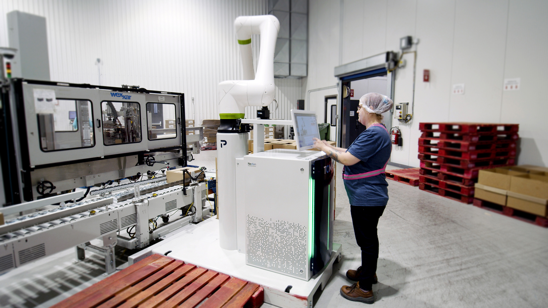 Opératrice travaillant en confiance avec un palettiseur cobot, illustrant comment les robots collaboratifs facilitent l’acceptation de l’automatisation